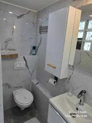 a white bathroom with a toilet and a sink at 4 logements à La Trinité proche de Nice 15 mn, Monaco 20 mn et l'Italie 30 mn 2 Chambres et 2 Studios privés et indépendants in La Trinité