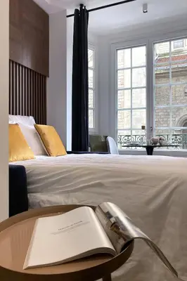 a hotel room with a bed with a book on a table at Superbe studio Plage/ Promenade des Anglais 102 in Nice