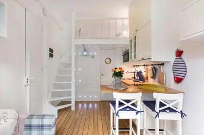 a kitchen with white cabinets and a table and chairs at On Board Captain in Nice