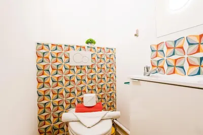 a bathroom with a toilet and a geometric shower curtain at PALAIS LIBERTE 4 AP4253 By Riviera Holiday Homes in Nice