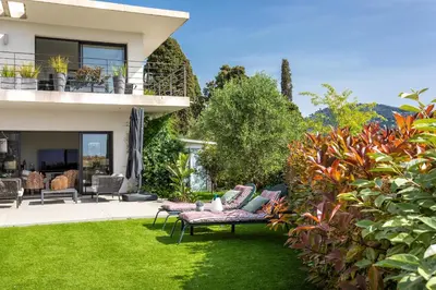 a garden with a bench in front of a house at Villa Les Sources VI4245 By Riviera Holiday Homes in Nice