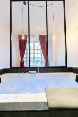 a hot tub in a room with windows at Jacuzzi-Nice quartier des musiciens-Loft in Nice