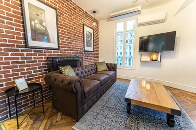 a living room with a couch and a brick wall at Jacuzzi-Nice quartier des musiciens-Loft in Nice