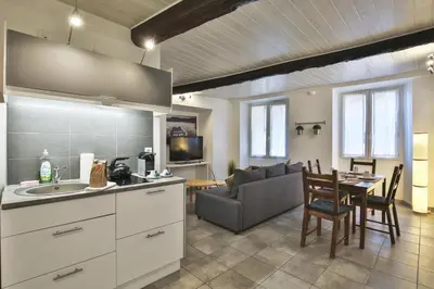 a kitchen and living room with a table and a couch at Jolie 2 pièces quartier Bonaparte/ Clim in Nice