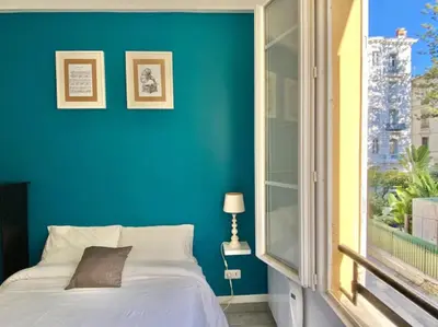 a blue bedroom with a bed and a window at Budget studio Berlioz in Nice