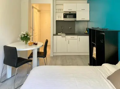 a room with a bed and a table and a kitchen at Budget studio Berlioz in Nice