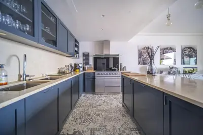 a large kitchen with blue cabinets and a sink at Superbe appartement Cap de nice in Nice