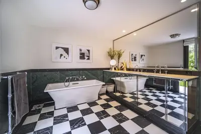 a bathroom with two tubs and a checkered floor at Superbe appartement Cap de nice in Nice