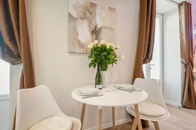 a white table with white chairs and a vase of flowers at Elegant Jacuzzi Loft in Central Massena in Nice