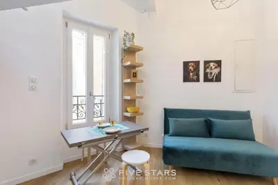 a living room with a blue couch and a table at Studio Fleur FSHH in Nice
