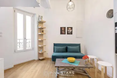 a living room with a blue couch and a table at Studio Fleur FSHH in Nice
