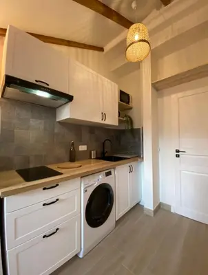 a kitchen with white cabinets and a washing machine at Lovely 1 Bedroom Apartment - Heart of Nice in Nice