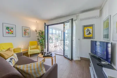 a living room with a couch and a tv at Appartement Liberation in Nice