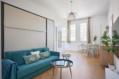 a living room with a blue couch and a table at Sunlight Properties - Daffia - Beautifully renovated studio, city pad in Central Nice in Nice