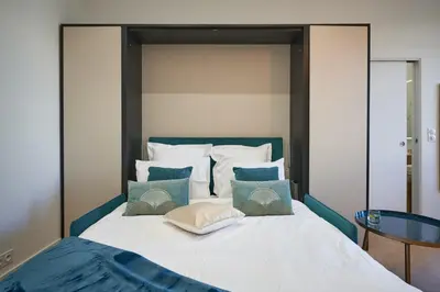 a bedroom with a large bed with a glass table at Sunlight Properties - Daffia - Beautifully renovated studio, city pad in Central Nice in Nice