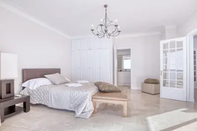 a white bedroom with a bed and a chandelier at Horizon Blue Lux Apartment in Nice