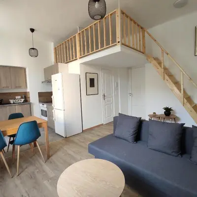 a living room with a blue couch and a kitchen at 2 à 6 personnes - WELCOME TO NICE ! LOGEMENT PORT in Nice
