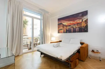 a bedroom with a bed and a large window at Promenade, 2pièces chic et clim avec terrasse Location éligible au Bail Mobilité Mobility Lease in Nice
