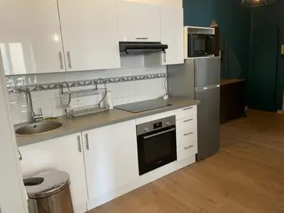 a kitchen with white cabinets and a sink and a refrigerator at Un havre de paix et de calme en plein centre de Massena in Nice