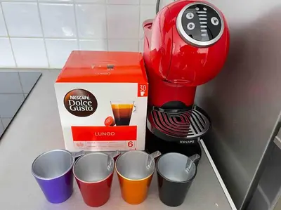 a red coffee maker with four cups next to a box at Un havre de paix et de calme en plein centre de Massena in Nice
