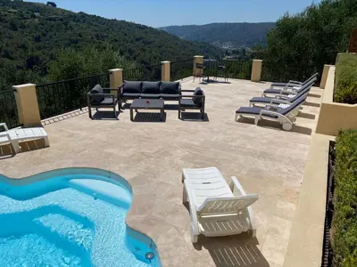 a patio with lounge chairs and a swimming pool at Villa avec piscine chauffée Nice collines in Nice