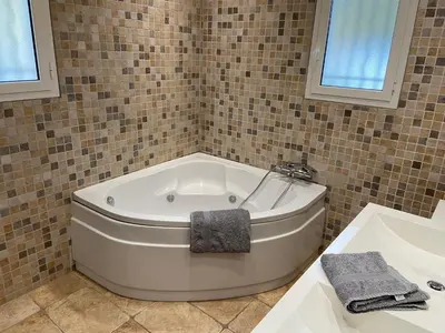 a white bath tub in a bathroom with a sink at Villa avec piscine chauffée Nice collines in Nice