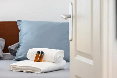 a pile of towels and a bottle of beer on a bed at FEEL HOME - BARILLERIE in Nice