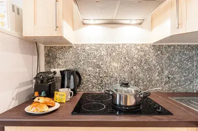 a kitchen counter with a pot on a stove with a plate of bread at FEEL HOME - BARILLERIE in Nice