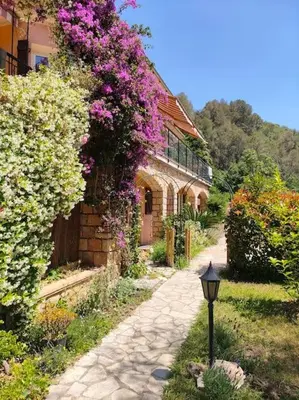 a house with pink flowers on the side of it at Un brin de paille in Cagnes-sur-Mer