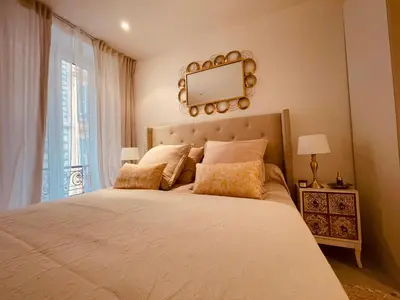 a bedroom with a large bed with a mirror on the wall at Nice Renting - PAGANINI - Spacious Apartment - 2 BedRooms - King Bed - Bathtub - Heart of Nice in Nice