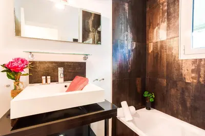 a bathroom with a white sink and a tub at LE TIVOLI AP4264 By Riviera Holiday Homes in Nice