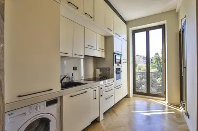 a kitchen with white cabinets and a washer and dryer at Balcon vue Coulée Verte. Luxe Plein cœur de Nice in Nice