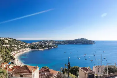 a view of a beach with boats in the water at Villefranche Sur Mer:Appartement-villa, Vue mer, jardin, parking. in Villefranche-sur-Mer