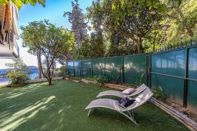 a chair sitting on the grass in a yard at Villefranche Sur Mer:Appartement-villa, Vue mer, jardin, parking. in Villefranche-sur-Mer
