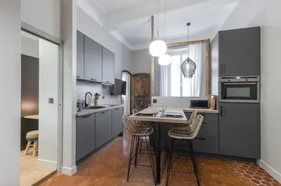 a kitchen with gray cabinets and a table with chairs at Charming 2 Bdr Old Town in Nice