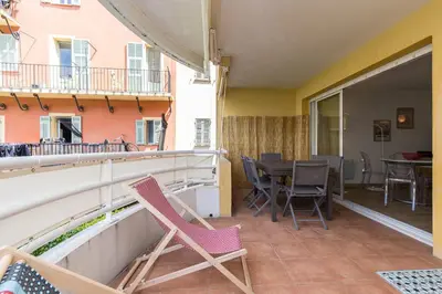 a balcony with chairs and a table on a balcony at Large 2 Bdr at Nice Port in Nice