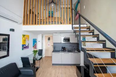 a kitchen and a living room with a staircase at Central Lamartine Flat - Brand New in Nice