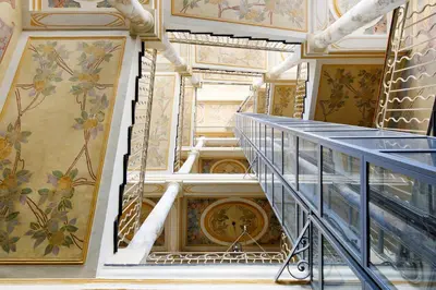 a staircase in a building with paintings on the walls at Maison Bianchi - Old Town Flower market in Nice