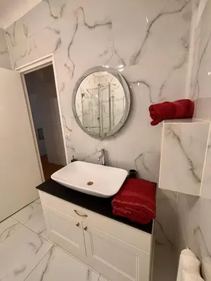 a white bathroom with a sink and a mirror at Le Nid Blanc Nice Centre in Nice