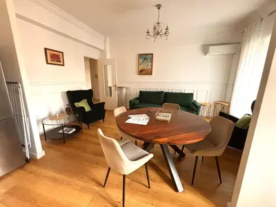 a living room with a table and a couch at Le Nid Blanc Nice Centre in Nice
