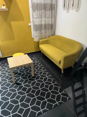 a living room with a green chair and a table at Charmant studio proche mer in Nice