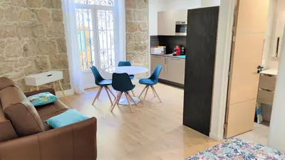 a living room with a couch and a table and chairs at hypercentre lamartine 001 in Nice