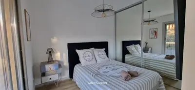 a bedroom with two beds and a mirror at HOME ET HOLIDAY Le Petit Manseng in Nice