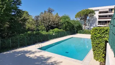 a swimming pool in front of a building at HOME ET HOLIDAY Le Petit Manseng in Nice