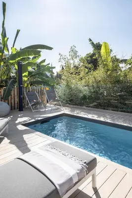 a swimming pool with a chaise lounge on a wooden deck at GROUND FLOOR VILLA GRAZIELLA 200 M FROM THE BEACH in Èze