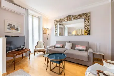 a living room with a couch and a mirror at From 1882, romantic flat, in the Golden Square in Nice