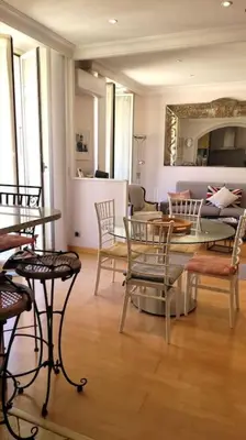 a living room with a table and chairs at From 1882, romantic flat, in the Golden Square in Nice