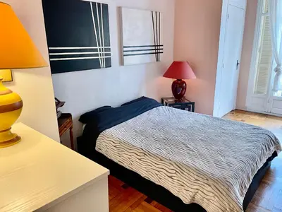 a bedroom with a bed and a table with a lamp at Seaside vintage studio in Nice