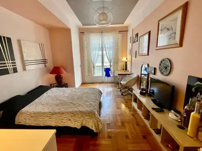 a bedroom with a bed and a television in it at Seaside vintage studio in Nice