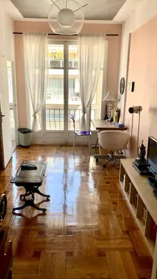 a large living room with a wooden floor and a table at Seaside vintage studio in Nice